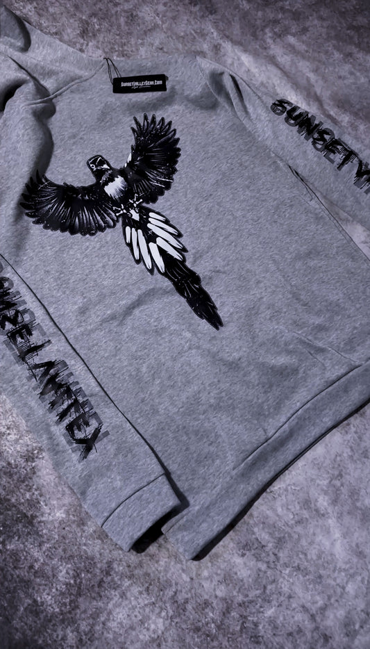 Gray sweatshirt with a bird design and text on a textured surface